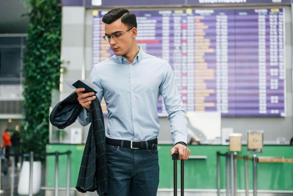 Foreign worker awaiting to travel to Singapore under the Personalised Employment Pass (PEP) with luggage and a work visa hand at an airport