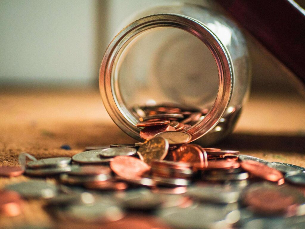 Coins falling from a jar, representing the cost to register a company in Singapore