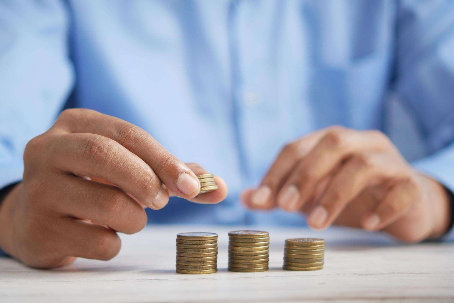 Business owner in Singapore placing coins on top each other, representing Singapore's role as a regional financial hub