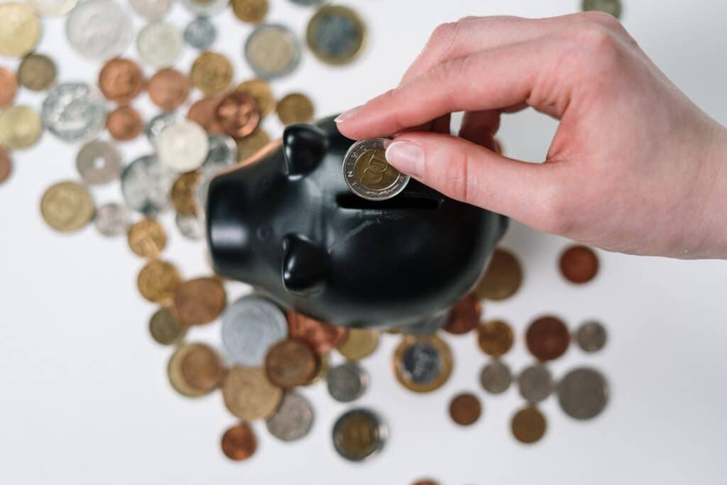 Employee placing coins in a piggy bank to represent the Progressive Wage Credit Scheme (PWCS) in Singapore